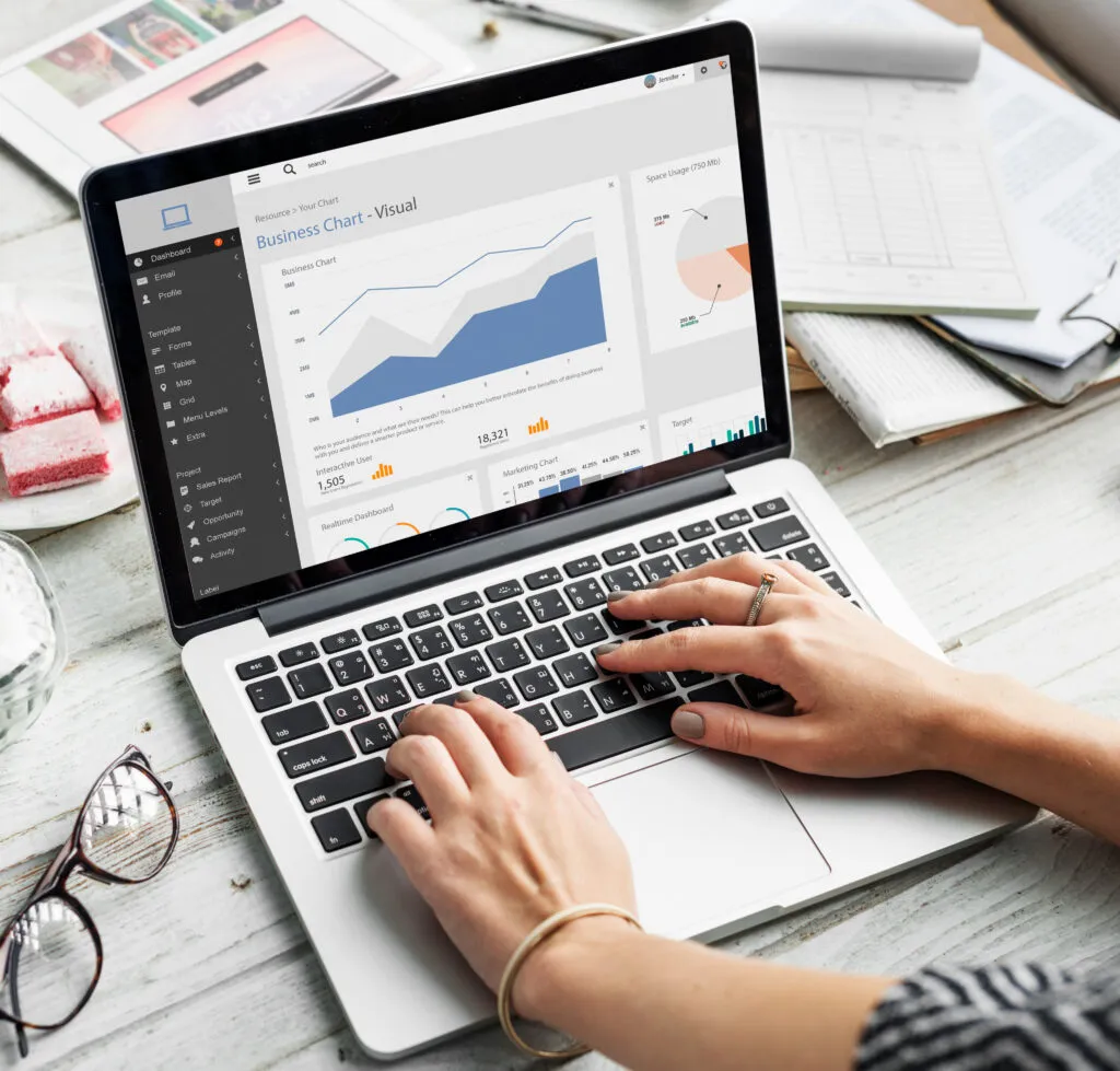 Portátil con gráficos y documentos sobre una mesa de trabajo