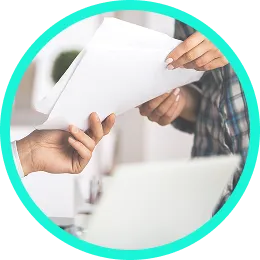 Manos entregando un documento sobre un portátil