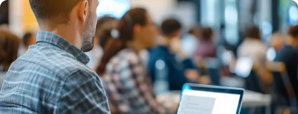 Asistentes a una sesión de formación con portátiles en una sala