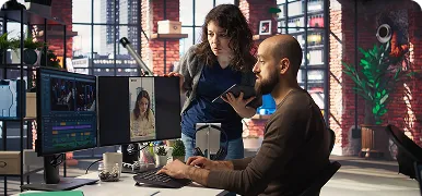 Dos compañeros revisando juntos su trabajo en el ordenador