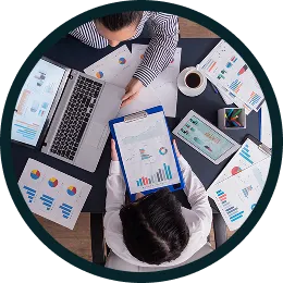 Vista cenital de un equipo analizando gráficos y documentos de sus procesos